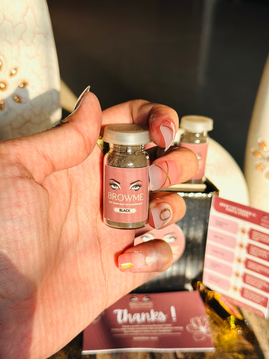 Hand holding a small container labeled 'Browme' with a blurred background